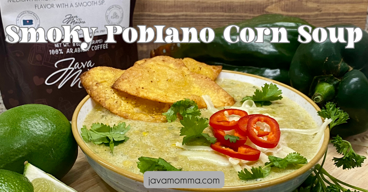 A cozy bowl of Smoky Poblano Corn Soup topped with queso fresco, fresh cilantro, sliced Fresno peppers, and crunchy tortilla strips, with a lime wedge on the side.