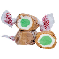 Thumbnail for Three pieces of Apple Pie Salt Water Taffy - Freeze-Dried, Sweet & Spiced Candy Crunch are wrapped in white paper with red print, showing tan exteriors and a white and green layered center, one cut open to reveal the colorful inside.