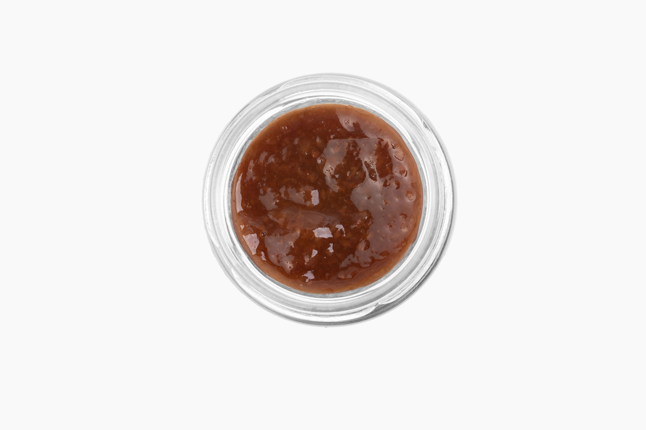 Top view of a small glass jar from the Mini Tea Jams Gift Set 🍯, filled with thick, brown, chunky gourmet tea-infused jam, placed on a white background.