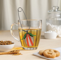 Thumbnail for A glass mug filled with loose leaf tea contains the Steep Fiend – The Loose Leaf Monster That Lives to Brew by OTOTO Studio, sitting on a light wooden table surrounded by cookies, extra loose tea, and a jar of sugar cubes.