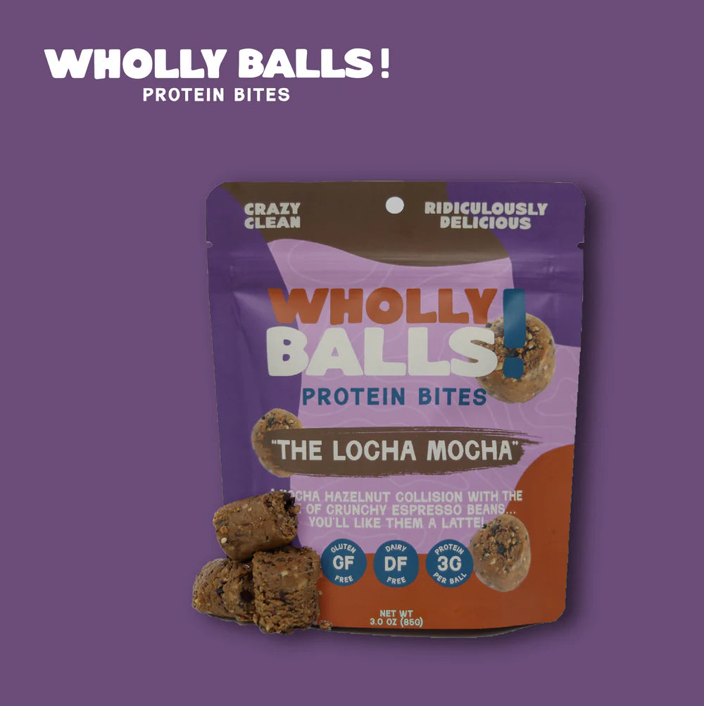 A pouch of The Loca Mocha – Mocha Hazelnut Espresso Wholly Balls | Plant-Based Protein Snack stands upright, with several espresso bean bites in front. The purple and brown packaging displays product features and details.