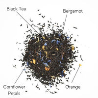 Thumbnail for A pile of Earl Grey’s Anatomy Loose Leaf Tea ☕ is labeled with arrows noting its ingredients: black tea, bergamot, orange, and blue cornflower petals. The blend features black leaves mixed with orange pieces and blue petals.
