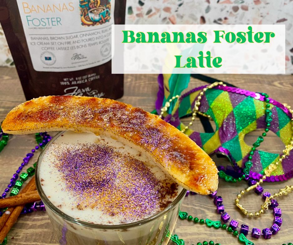 A festive Bananas Foster Latte topped with a brûléed banana and shimmering purple, gold, and green sugar, served in a glass with frothy milk. Mardi Gras beads and a vibrant masquerade mask add a celebratory New Orleans flair in the background.