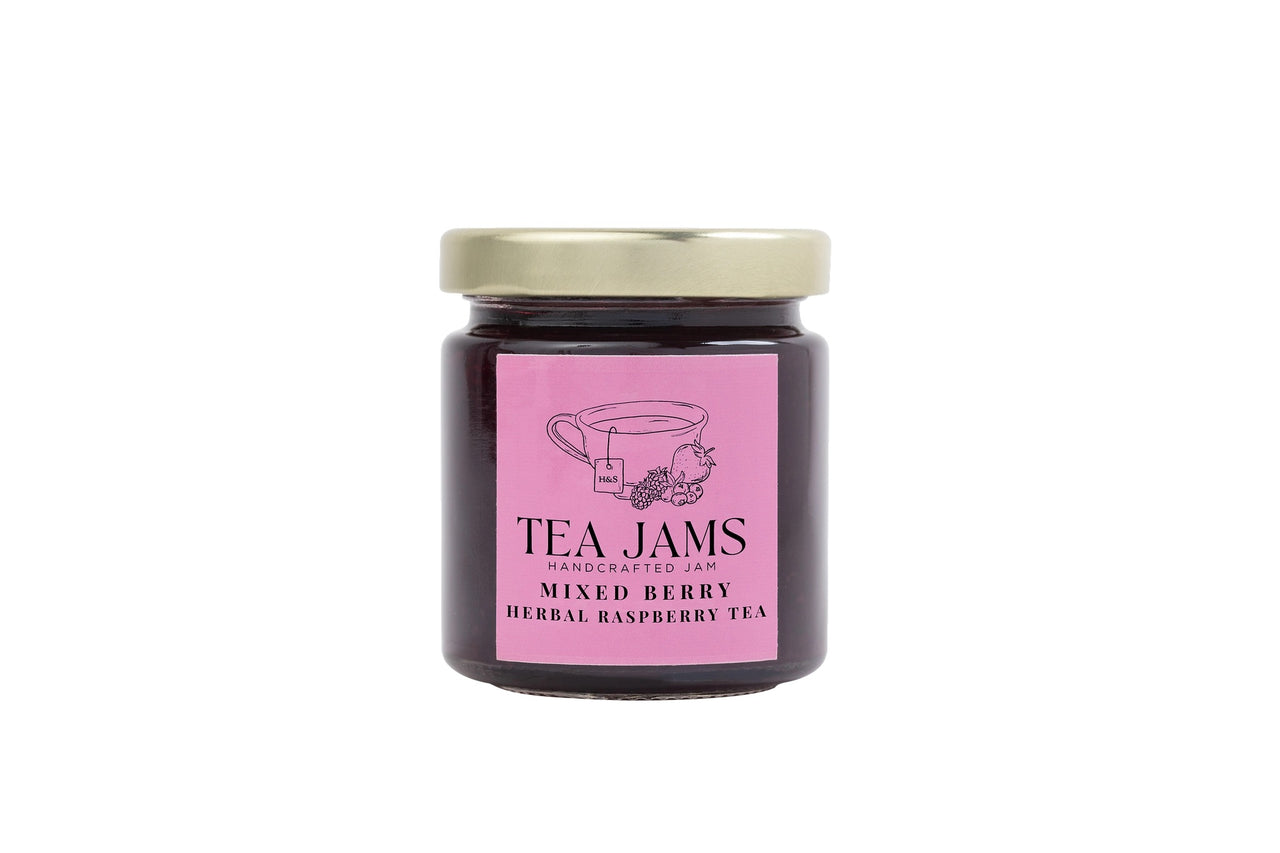 A glass jar with a gold lid holds dark jam. The pink label reads “Tea Jams Handcrafted Jam, Mixed Berry, Herbal Raspberry Tea” with a teacup and berries—part of the Mini Tea Jams Gift Set 🍯 – Gourmet Tea-Infused Jam Sampler.