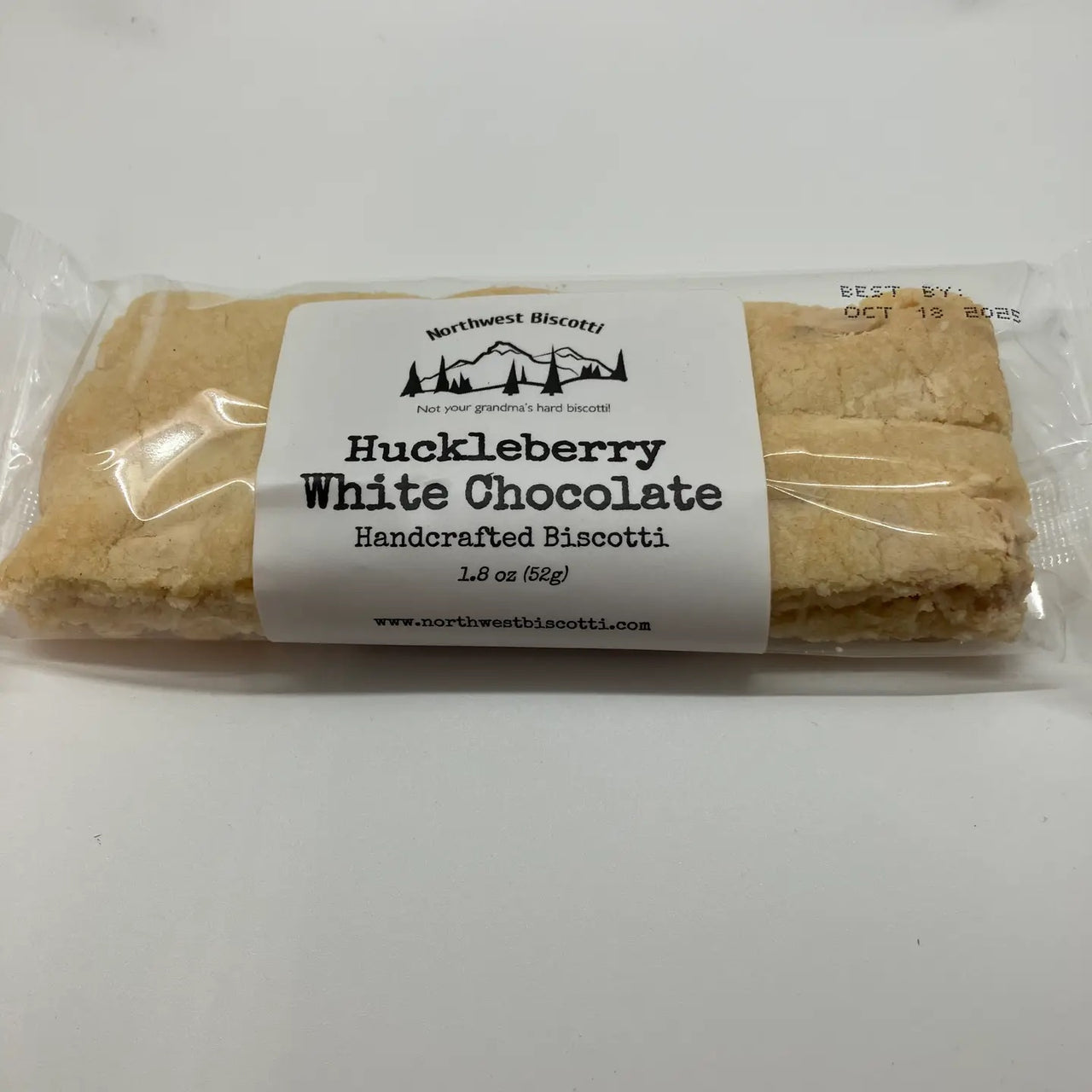 A packaged Huckleberry White Chocolate Biscotti – Sweet, Tart & Soft-Bite Perfect, with real huckleberries and white chocolate visible through clear plastic wrapping.