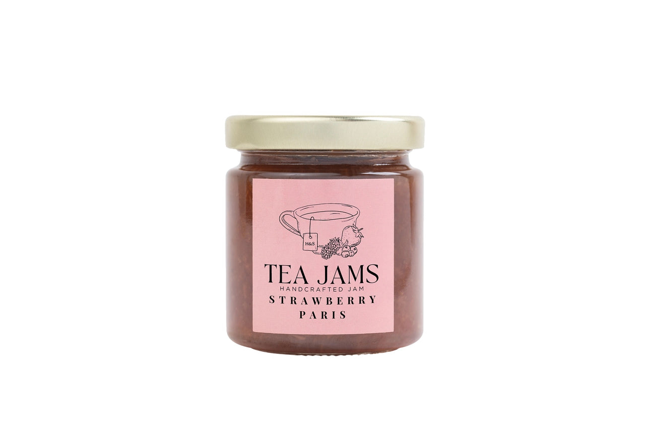 A glass jar of gourmet tea-infused strawberry jam with a gold lid. The pink label reads Mini Tea Jams Gift Set – Handcrafted Jam Strawberry Paris, inspired by Harney & Sons teas, and features a teacup and strawberry illustration.