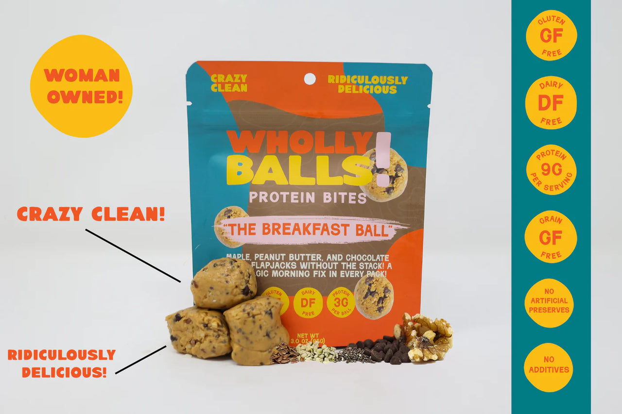 A package of Breakfast Balls – Maple Peanut Butter Chocolate Chip Wholly Balls is surrounded by stacked bites, nuts, oats, and chocolate chips. Callouts showcase this plant-based, protein-packed snack as woman owned and crazy clean—perfect for breakfast.