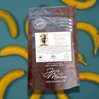 Thumbnail for A bag of 🍌 Bananas Foster Storm medium roast coffee, featuring caramelized banana, brown sugar, and rum notes, rests on a teal background with bananas. The packaging displays detailed text and graphics about its flavor profile.