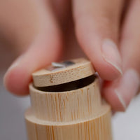 Thumbnail for A close-up of a hand holding a wooden pencil sharpener, about to sharpen a pencil, highlighting the eco-friendly design—similar to the Bamboo Floss Holder with Charcoal Floss: gentle, refillable, and sustainable oral care.