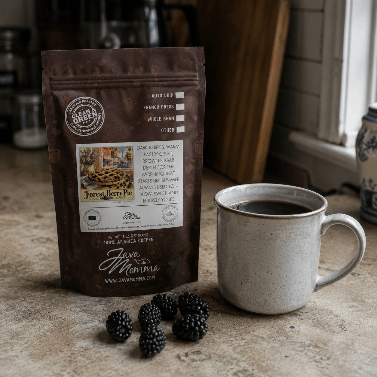 Java Momma Forest Berry pie coffee package with a mug of coffee on a rustic surface