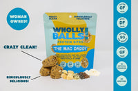 Thumbnail for A bag of The Mac Daddy – White Chocolate Macadamia Wholly Balls, a plant-based protein snack with macadamia nuts, seeds, and chocolate, stands upright beside the bites. Highlights: gluten-free, dairy-free, 9g protein, woman-owned, clean ingredients.