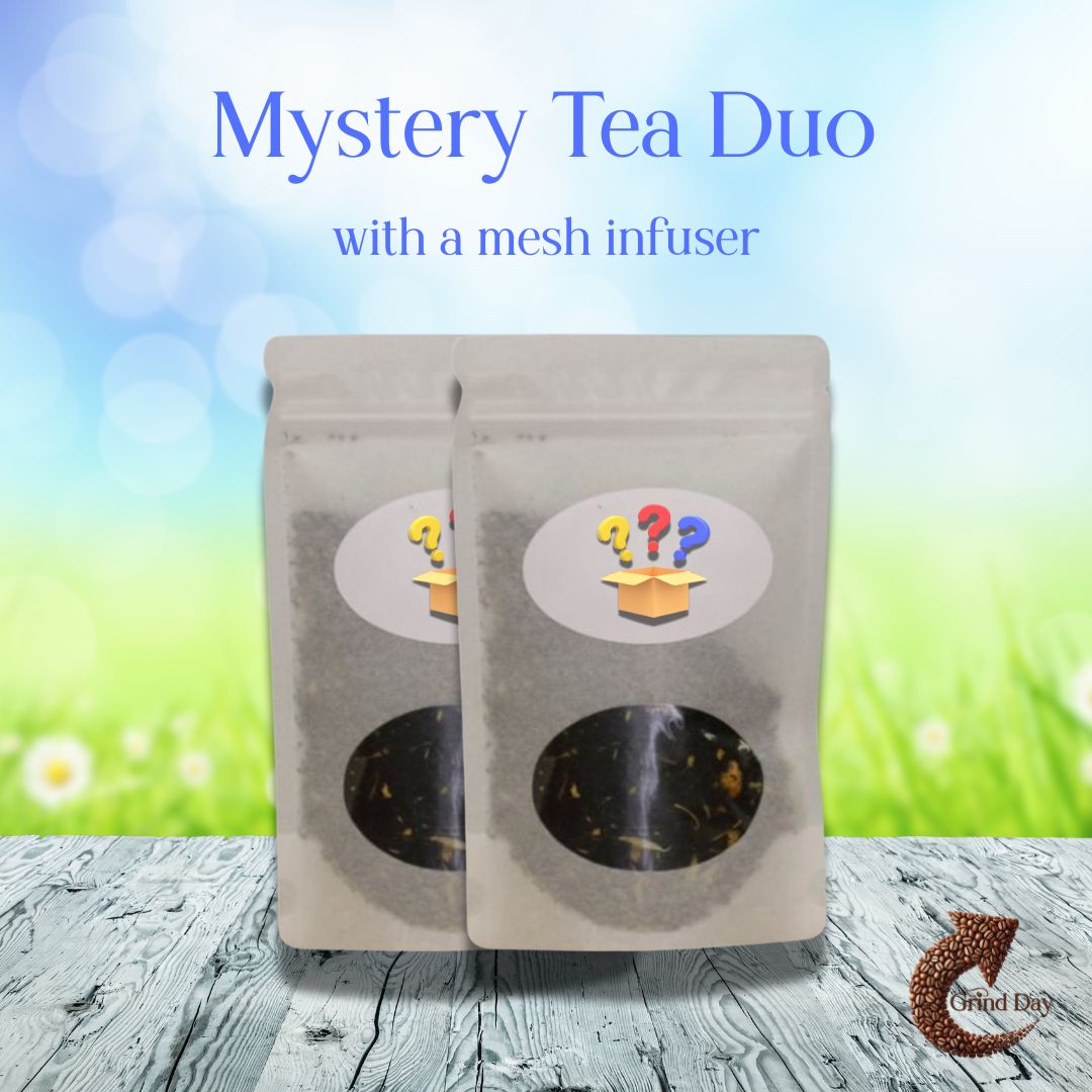 Two sealed bags of loose leaf tea, labeled with a mystery box and question marks, sit on a wooden surface with a grassy blurred background. Text: 🍵 Mystery Tea Duo – Sip, Savor, Surprise! Includes mesh tea infuser. Limited-time offer.