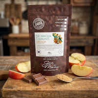 Thumbnail for Nicaragua Diamante coffee package with apples and chocolate on a wooden surface