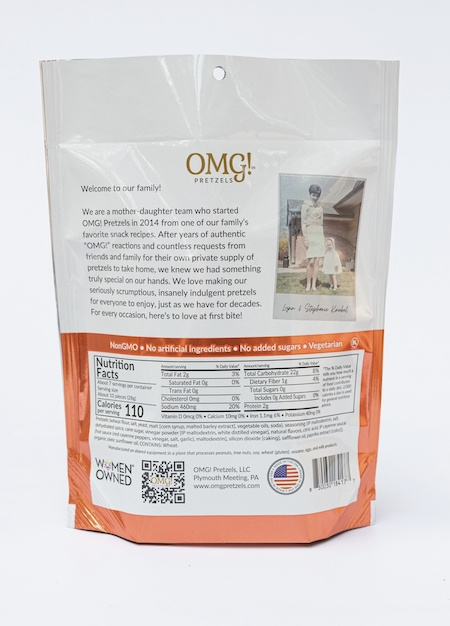Back of a bag of OMG Pretzels - Buffalo Sourdough Pretzel Nuggets, with a welcome message, family photo, nutrition facts, certifications, and product info. This spicy snack features buffalo seasoning and is non-GMO, vegetarian, and women-owned.