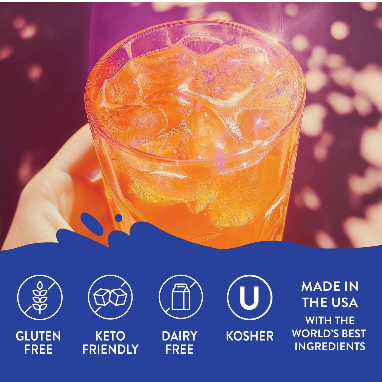 A hand holds a glass of Orange Soda Skinny Syrup – Bright, Bubbly & Totally Throwback 🍊🥤✨ with ice. Icons below show it’s gluten free, keto-friendly, dairy free, kosher, and made in the USA. Purple and orange tones highlight the scene.