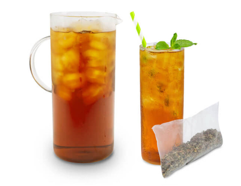 A pitcher and tall glass of Mint Condition Refreshing Peppermint Cold Brew Tea with ice, green striped straw, mint garnish, and tea bag—perfect for enjoying this caffeine-free herbal beverage.