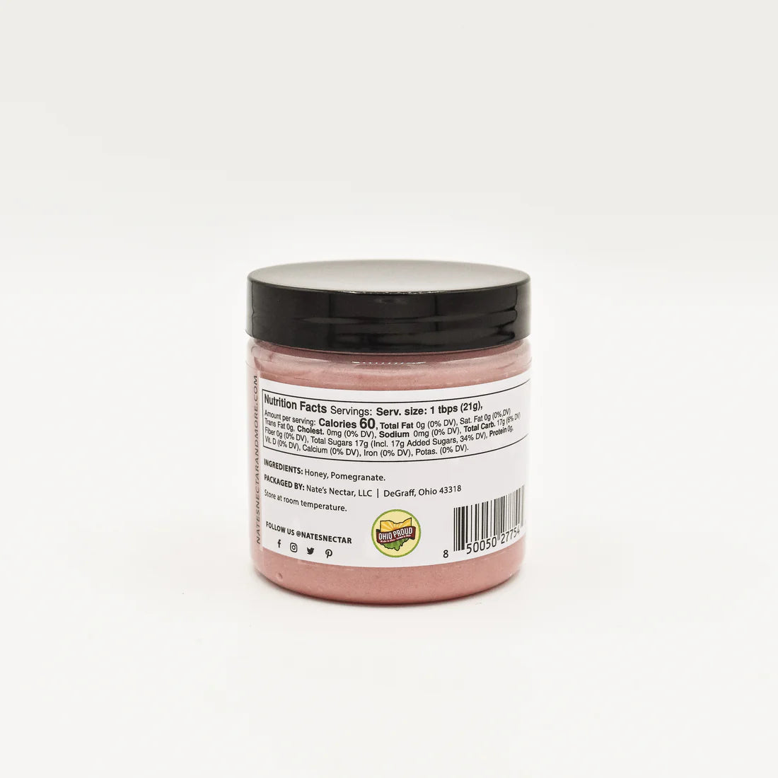 A small jar of Nate’s Nectar Pomegranate Creamed Honey – Bold, Sweet & Irresistibly Smooth, with a black lid and pink honey inside. The back label details nutrition facts, ingredients, and company info. The jar sits on a plain white background.