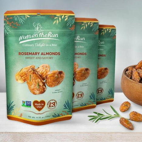 Three pouches of Nuts & The Run Rosemary Almonds are displayed on a light wooden surface with a wooden bowl and a few loose almonds against a soft light blue-green background.