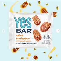 Thumbnail for The Maple Pecan YES Bar® – Sweet, Salty, and Oh-So-Satisfying is displayed on a light blue background with pecans, cashews, and maple syrup. The packaging features plant-based and gluten-free “V” and “GF” symbols.
