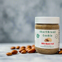 Thumbnail for A jar of Shortbread Cookie 🫓 with Monk Fruit Nut Butter – Buttery, Sweet & Sugar-Free Bliss sits on a gray surface among whole almonds, set against a softly blurred, neutral background.