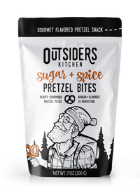 Thumbnail for A 7 oz (200 g) bag of Sugar + Spice Pretzel Bites – Sweet, Salty, and Straight-Up Craveable 🍬🔥, crafted in small batches, with a black-and-white illustration of a bearded man in outdoor gear holding a pretzel amid trees and mountains.