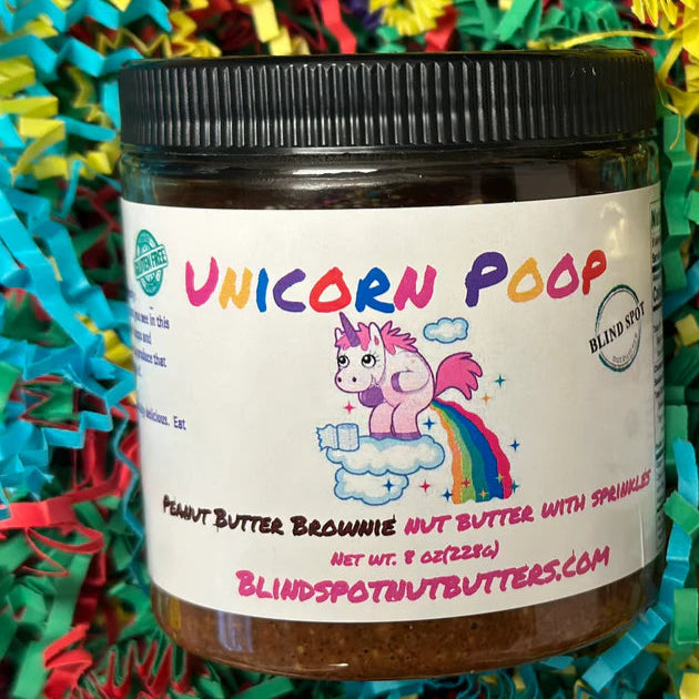 Two jars of 'Unicorn Poop' peanut butter on colorful paper
