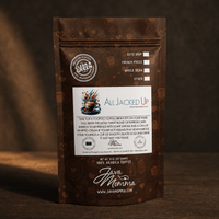 Thumbnail for Java Momma All Jacked Up Espresso Blend coffee bag standing upright on a dark wood surface in warm moody side light