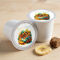 Thumbnail for Two 'Bananas Foster' coffee pods on a wooden surface with a banana and brown sugar cube.