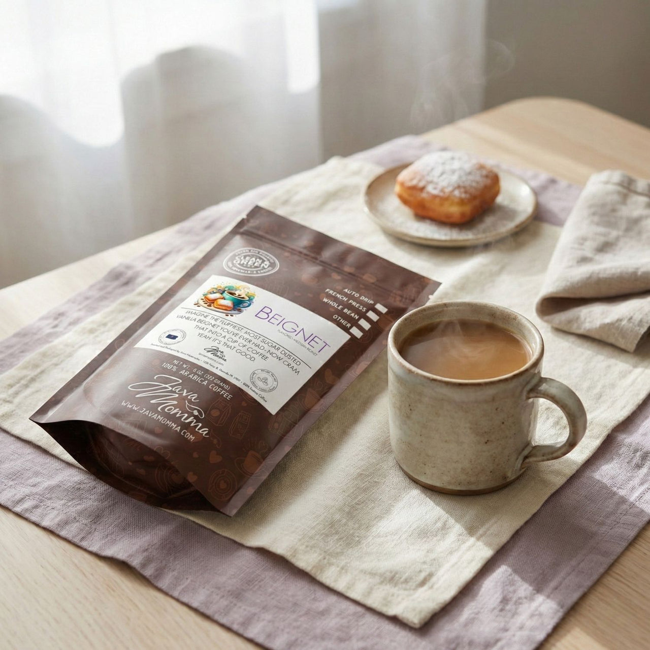 Beignet Coffee package and cup on a table with a plate of pastries