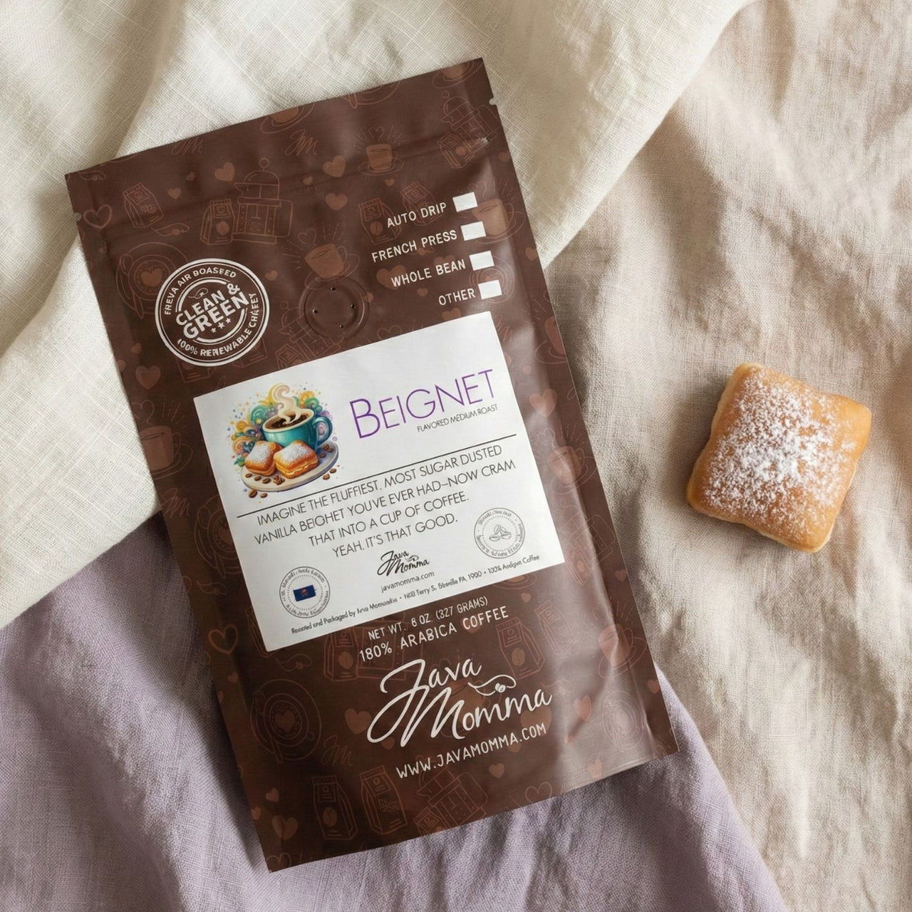 Java Momma coffee package with a beignet on a textured fabric background