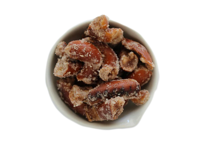 A white bowl holds Sugar + Spice Pretzel Bites—sweet, salty, and straight-up craveable snack—presented against a plain background.