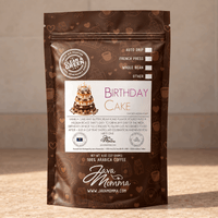 Thumbnail for A stand-up pouch of Java Momma Coffee's 'Birthday Cake' flavored medium roast whole bean coffee, featuring a brown packaging design with cake illustrations and a white label, set against a neutral beige background.