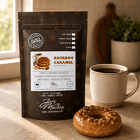 Thumbnail for Bourbon Caramel Donut coffee bag next to a ceramic mug with a caramel glazed donut topped with pecans