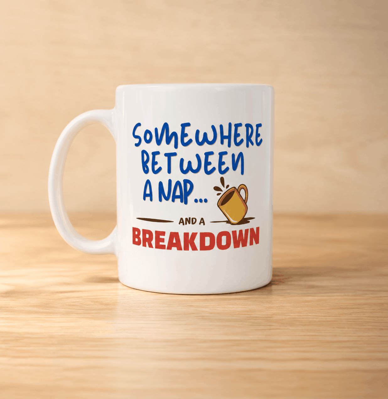 White mug with humorous text design on a wooden surface - somewhere between a nap and a breakdown
