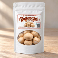 Thumbnail for A white stand-up pouch of Butterscotch Salt Water Taffy freeze-dried munchies, featuring a clear window that displays the golden-brown taffy pieces inside. The packaging has a white background with a warm brown and orange label.