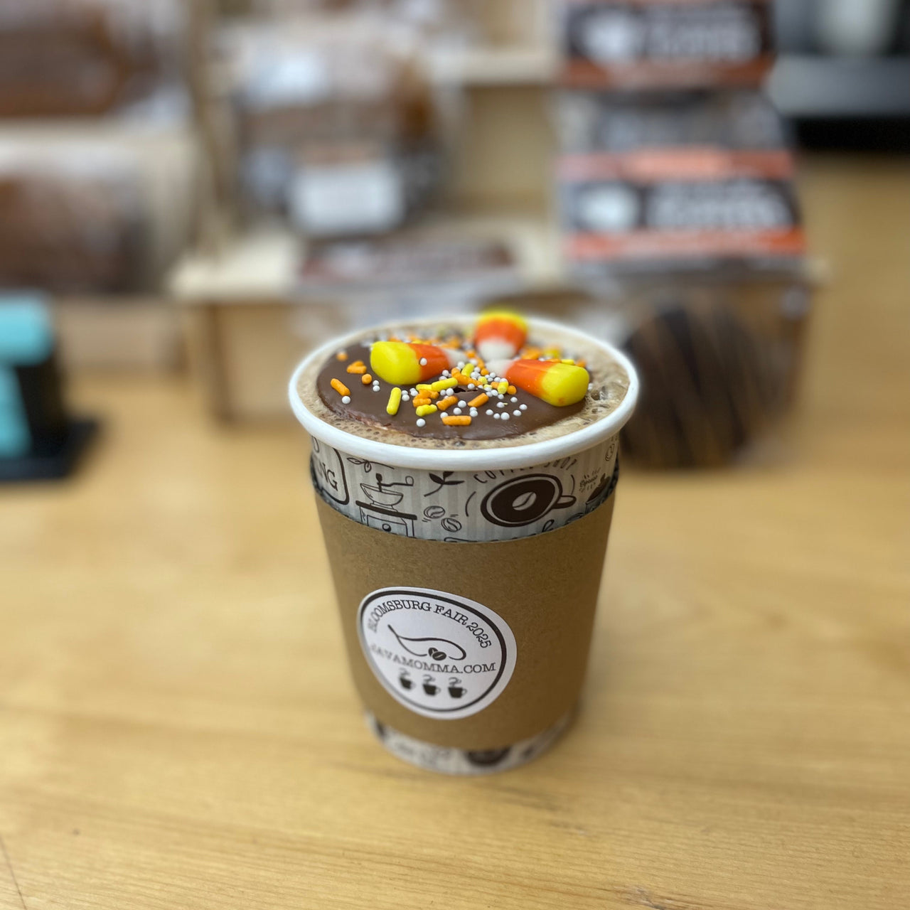 Coffee cup with sprinkles on a wooden surface, blurred background