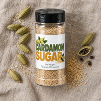 Thumbnail for Cardamom Sugar Sprinkle in a jar with cardamom pods on a textured background, perfect for drinks and desserts.