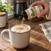 Thumbnail for A hand sprinkles Cardamom Sugar Sprinkle onto a latte, adding a warm, floral finish to the drink.