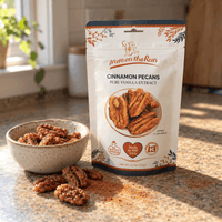 Thumbnail for A stand-up pouch of Wato on the Run Cinnamon Pecans Pure Vanilla Extract stands on a kitchen countertop beside a small speckled bowl of pecans and scattered cinnamon powder. Sunlight streams across the counter, with a blurred kitchen background.