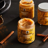 Thumbnail for Three jars of Cinnamon Stick Honey Cream Spread 🍯 – Cozy Cinnamon Bun Bliss in a Jar sit on a dark surface, one open to reveal creamy swirls. Nearby, cinnamon sticks and spice powder add a cozy, spiced touch.