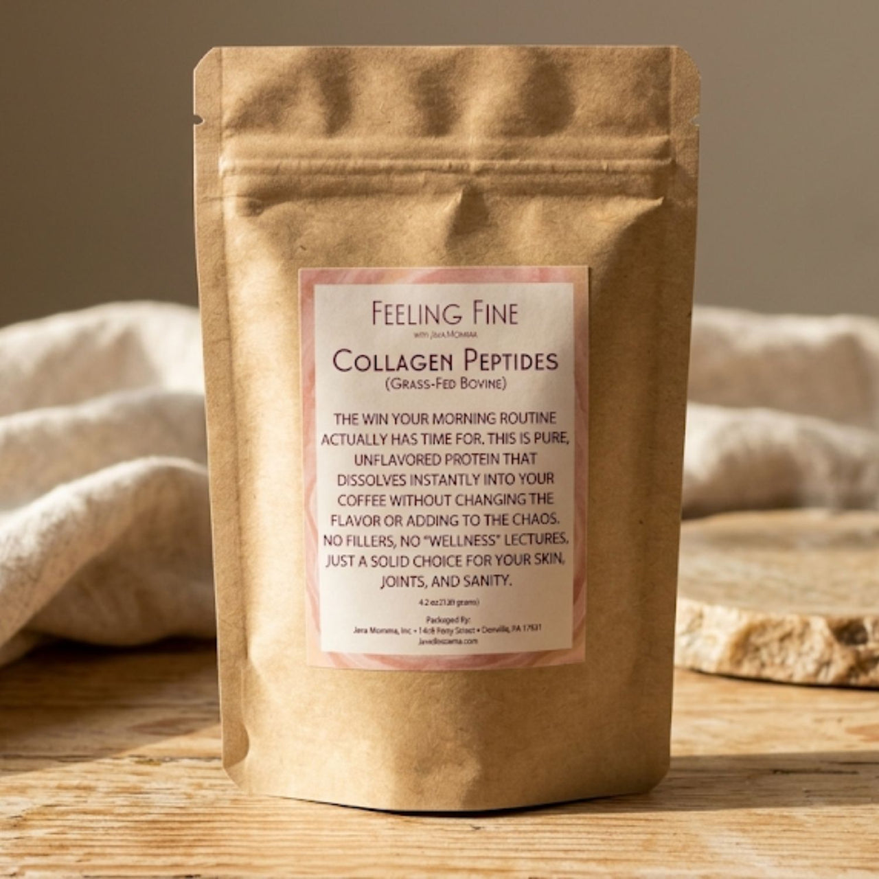 Kraft paper package of 'Feeling Fine' collagen peptides on a wooden surface with a beige towel in the background.