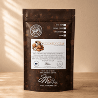 Thumbnail for Front view of Java Momma Cookiedoodle flavored medium roast coffee bag standing upright on a wooden table with warm, dappled lighting.