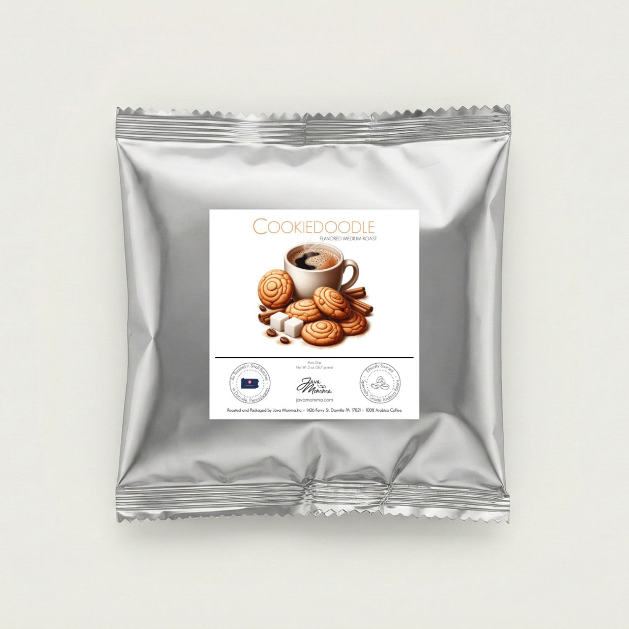Silver foil 2 ounce sample packet of Java Momma Cookiedoodle flavored medium roast coffee centered on a minimalist white background.