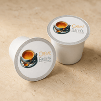Thumbnail for Two coffee pods labeled 'Crème Bruleé' on a beige surface
