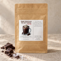 Thumbnail for Dairy Free Dark Chocolate Sea Salt Hot Cocoa Mix packaging with a mug of hot cocoa and dark chocolate pieces.