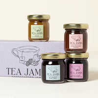 Thumbnail for Four jars of the Mini Tea Jams Gift Set 🍯 – a gourmet tea-infused jam sampler with gold lids – are shown, three atop a lavender “Tea Jams” box. Flavors include mango, strawberry, blueberry, and mixed berry made with Harney & Sons teas.