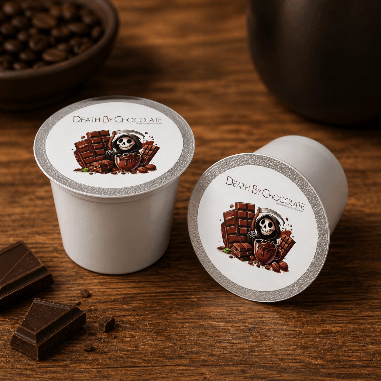 Two 'Death By Chocolate' coffee pods on a wooden surface with chocolate pieces.