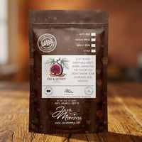 Thumbnail for Java Momma Fig & Honey Coffee 8 oz bag standing upright on a warm wood surface with a soft amber blurred background
