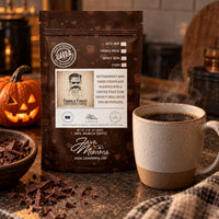 Thumbnail for A bag of Frank's Finest Coffee. 'Bittersweet and Dark Chocolate' coffee stands on a countertop beside a cup of hot coffee, with chocolate pieces in a bowl and a pumpkin in the background.