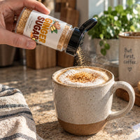 Thumbnail for Hand sprinkling Ginger Sugar Sprinkle over a frothy coffee in a cozy kitchen.
